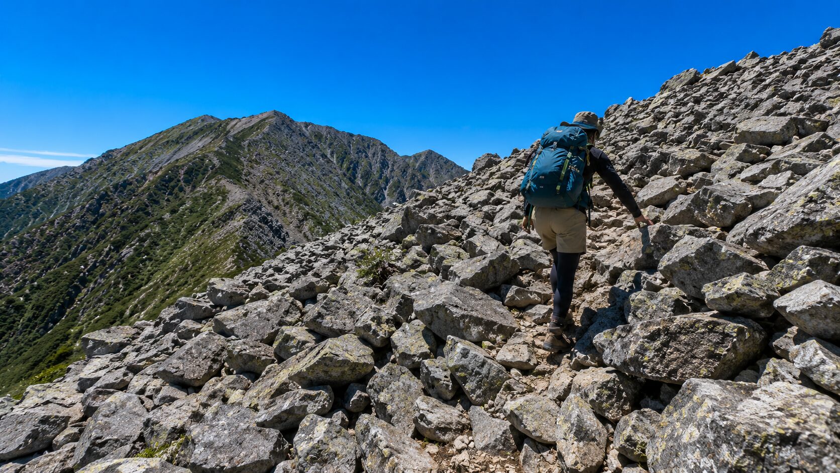 釈迦ヶ岳のガレ場急斜面を登る登山者